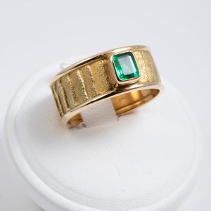 Anello a fascia oro giallo 18k con smeraldo